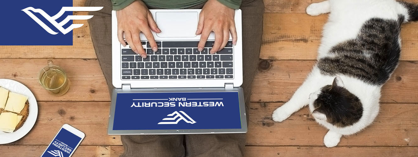 Photo of Person working on a laptop with their smart phone next to them