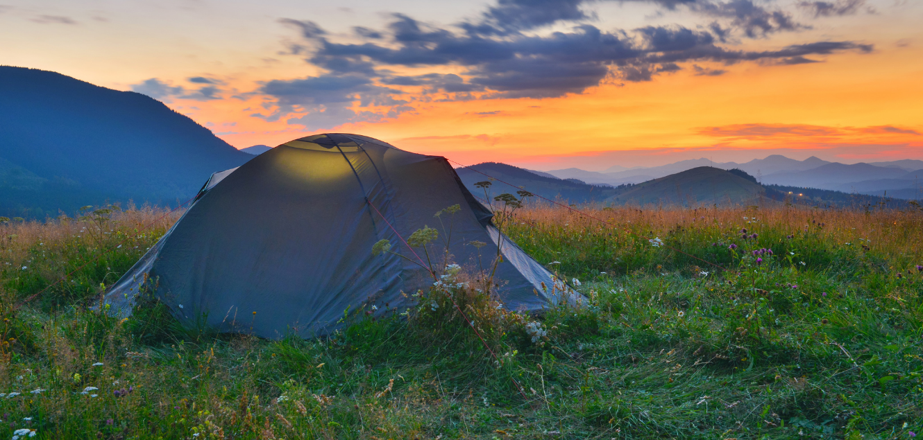 Tent in front of mountains at sunset